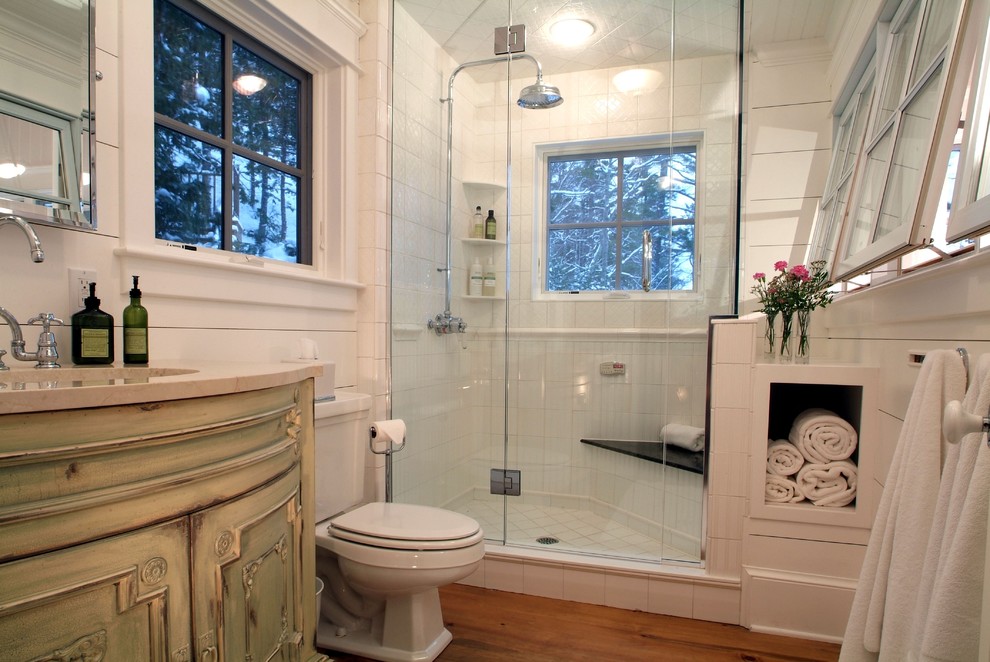 Idée de décoration pour une salle d'eau marine en bois vieilli de taille moyenne avec un placard en trompe-l'oeil, une douche d'angle, WC séparés, un carrelage blanc, des carreaux de porcelaine, un mur blanc, parquet foncé, un lavabo encastré, un plan de toilette en marbre, un sol marron et une cabine de douche à porte battante.