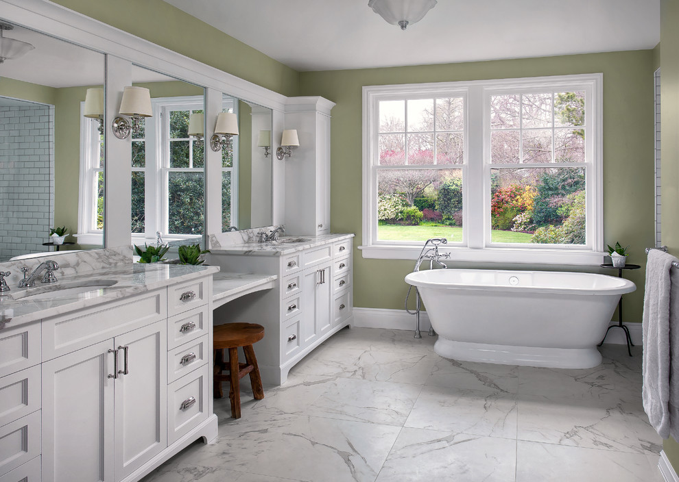 Idées déco pour une salle de bain principale classique avec un placard à porte shaker, des portes de placard blanches, une baignoire indépendante, un mur vert, un sol en marbre, un lavabo encastré, un plan de toilette en marbre et un sol blanc.