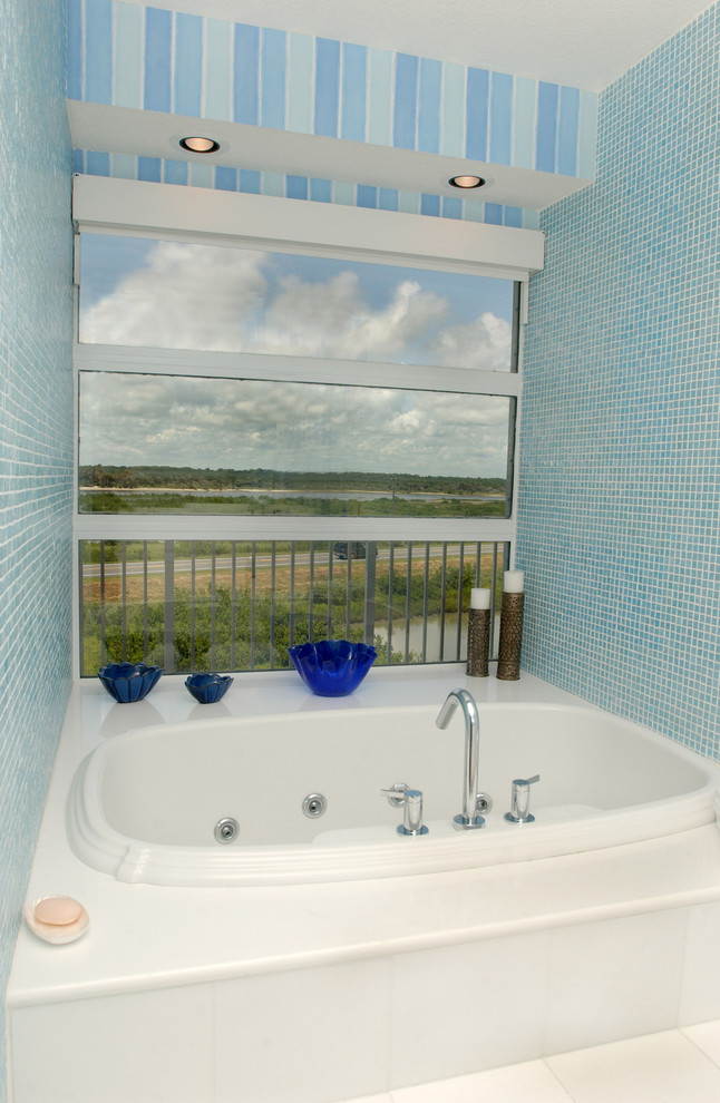 Пример оригинального дизайна: большая главная ванная комната в морском стиле с гидромассажной ванной и стеклянной плиткой