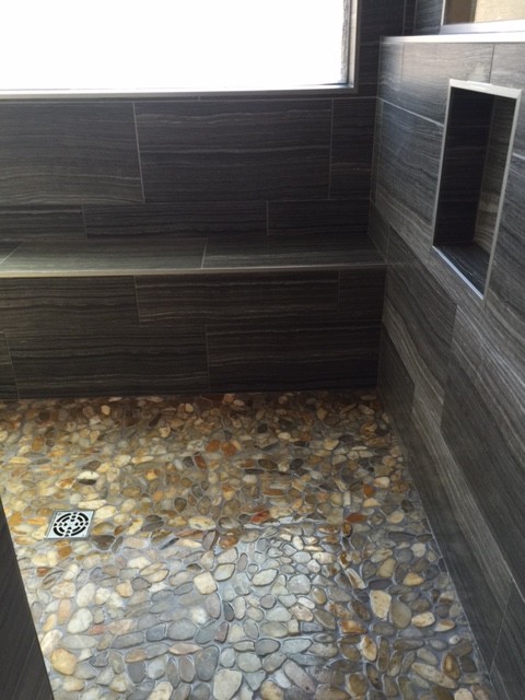 Exemple d'une salle de bain principale bord de mer de taille moyenne avec une douche ouverte, un carrelage gris et une plaque de galets.