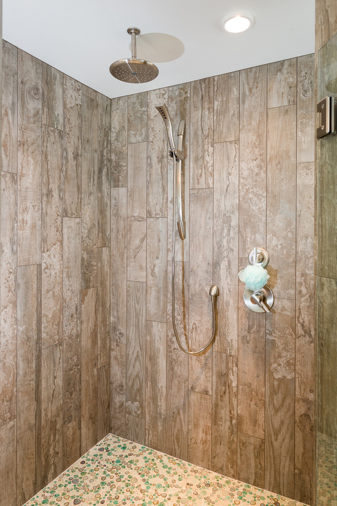Diseño de cuarto de baño principal costero con ducha empotrada, baldosas y/o azulejos grises, baldosas y/o azulejos de cemento y suelo de baldosas tipo guijarro