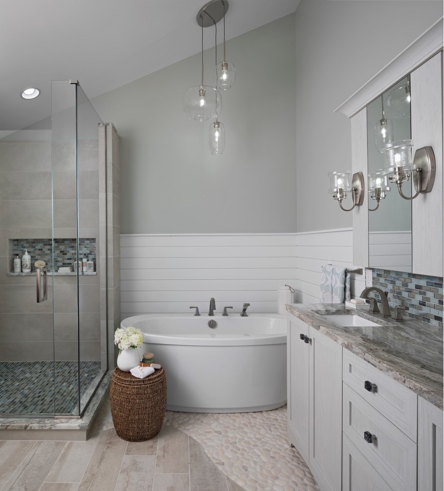 Example of a large beach style master beige tile and porcelain tile porcelain tile and beige floor bathroom design in Detroit with shaker cabinets, white cabinets, a two-piece toilet, gray walls, an undermount sink, granite countertops, a hinged shower door and brown countertops