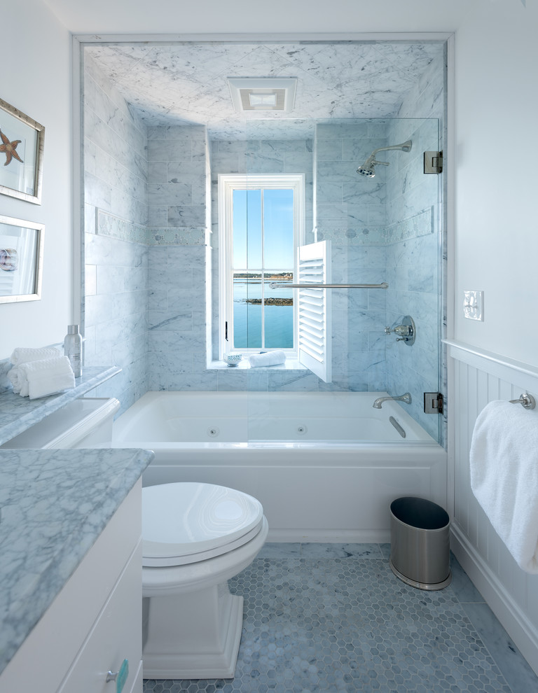 На фото: маленькая главная ванная комната в морском стиле с плоскими фасадами, белыми фасадами, ванной в нише, душем над ванной, раздельным унитазом, серой плиткой, мраморной плиткой, белыми стенами, мраморным полом, врезной раковиной, мраморной столешницей, серым полом и душем с распашными дверями для на участке и в саду