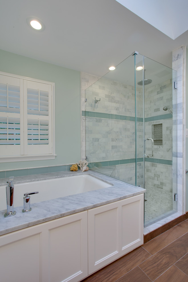 Medium sized contemporary ensuite bathroom in DC Metro with white cabinets, marble worktops, a corner shower, green walls, medium hardwood flooring, recessed-panel cabinets, grey tiles, stone tiles, a submerged sink, brown floors and a hinged door.