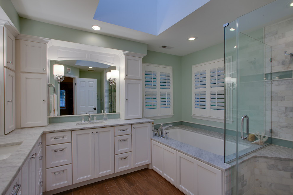 Foto på ett mellanstort funkis en-suite badrum, med vita skåp, marmorbänkskiva, en hörndusch, gröna väggar, mellanmörkt trägolv, luckor med infälld panel, grå kakel, stenkakel, ett undermonterad handfat, brunt golv och dusch med gångjärnsdörr