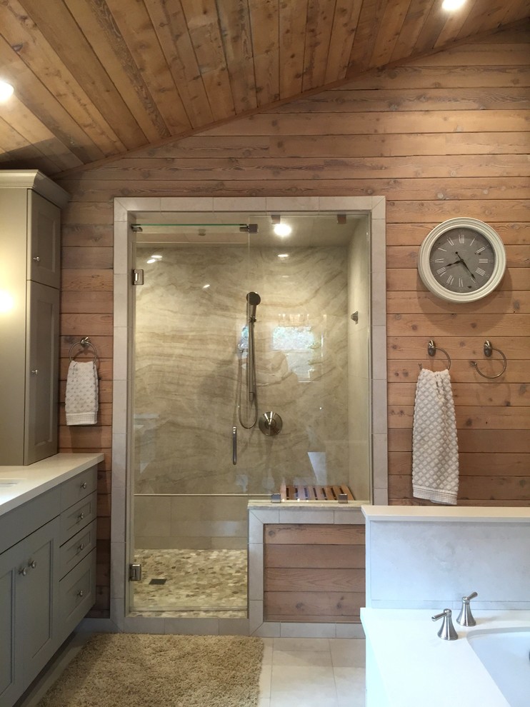 Mid-sized beach style master beige tile and stone slab porcelain tile alcove shower photo in San Diego with recessed-panel cabinets, gray cabinets, an undermount tub, beige walls, an undermount sink, quartz countertops and a hinged shower door