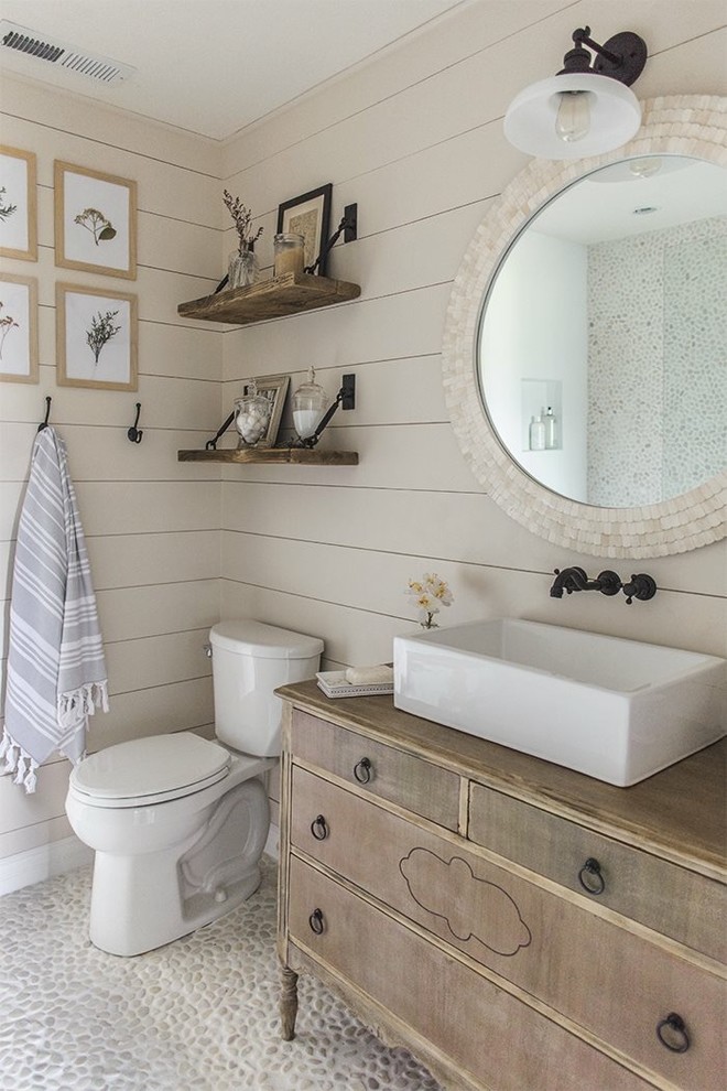 Idéer för att renovera ett litet maritimt brun brunt badrum med dusch, med skåp i slitet trä, en toalettstol med separat cisternkåpa, beige väggar, klinkergolv i småsten, ett fristående handfat, träbänkskiva, grått golv och släta luckor