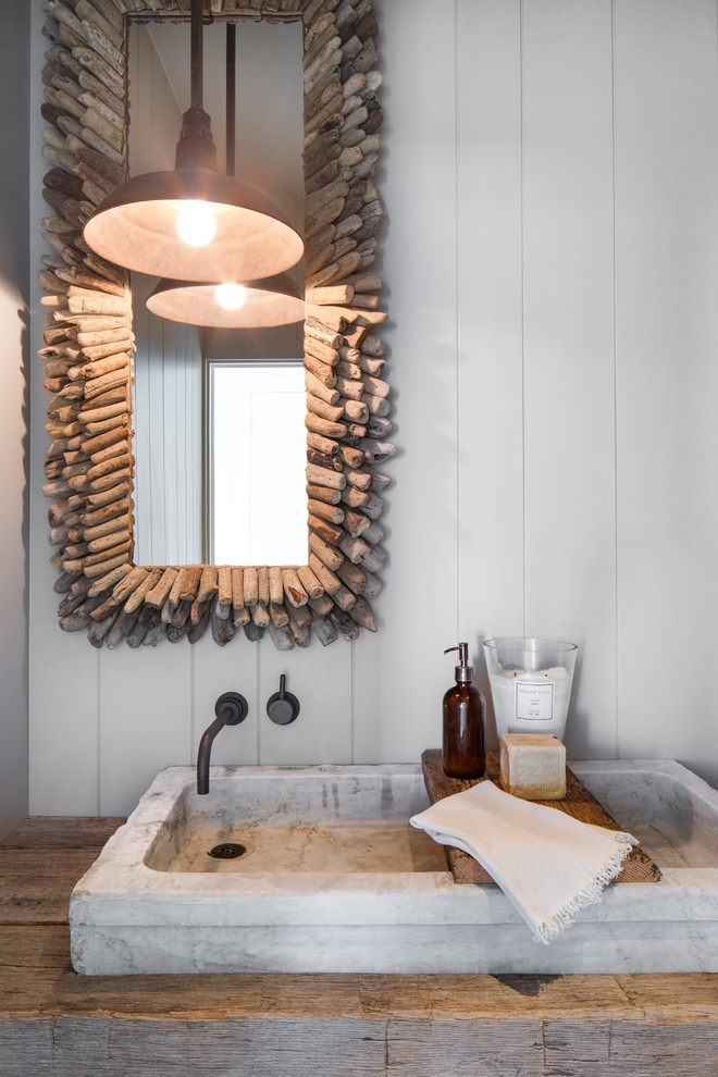 Diseño de cuarto de baño costero con paredes blancas, lavabo sobreencimera, encimera de madera y encimeras marrones