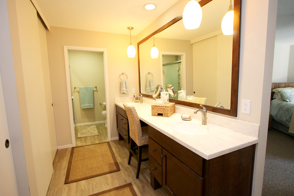 Immagine di una stanza da bagno padronale stile marinaro di medie dimensioni con lavabo integrato, consolle stile comò, ante in legno bruno, top in superficie solida, piastrelle bianche e pareti beige