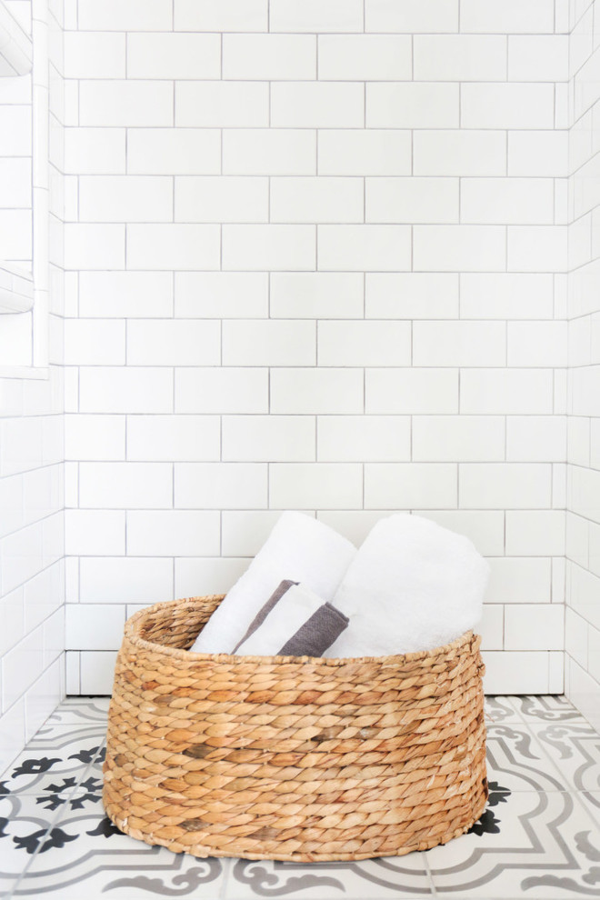 Maritim inredning av ett mellanstort en-suite badrum, med luckor med infälld panel, vita skåp, en öppen dusch, svart och vit kakel, vita väggar, ett undermonterad handfat, marmorbänkskiva och tunnelbanekakel