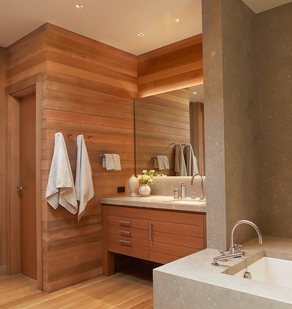 サンフランシスコにあるビーチスタイルのおしゃれなマスターバスルーム (アンダーカウンター洗面器、フラットパネル扉のキャビネット、中間色木目調キャビネット、アンダーマウント型浴槽、茶色い壁、無垢フローリング) の写真