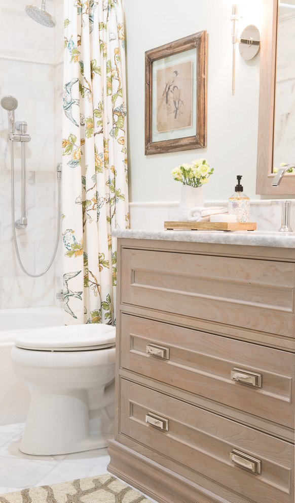 Example of a mid-sized beach style white tile and stone tile marble floor alcove bathtub design in Miami with beaded inset cabinets, light wood cabinets, a two-piece toilet, blue walls, an undermount sink and quartzite countertops