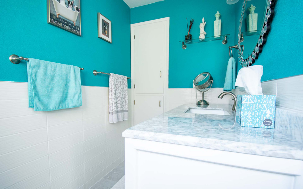 Example of a large beach style master white tile and ceramic tile ceramic tile, gray floor and single-sink bathroom design in Portland with shaker cabinets, white cabinets, a two-piece toilet, blue walls, an undermount sink, quartz countertops, gray countertops and a built-in vanity