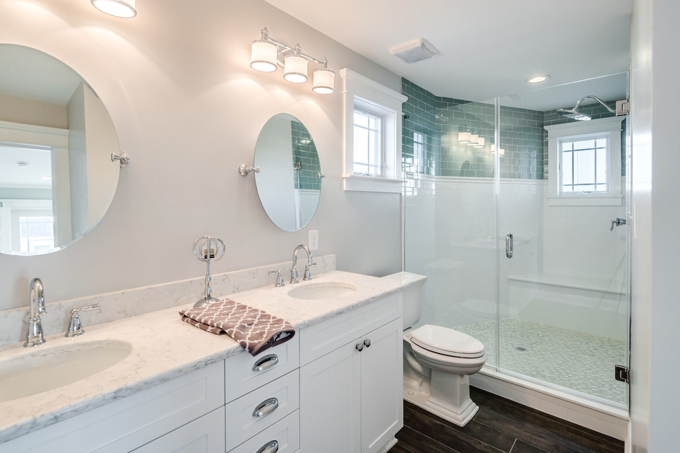 Пример оригинального дизайна: большая главная ванная комната в морском стиле с фасадами в стиле шейкер, белыми фасадами, двойным душем, раздельным унитазом, синей плиткой, стеклянной плиткой, белыми стенами, полом из керамической плитки, врезной раковиной и мраморной столешницей