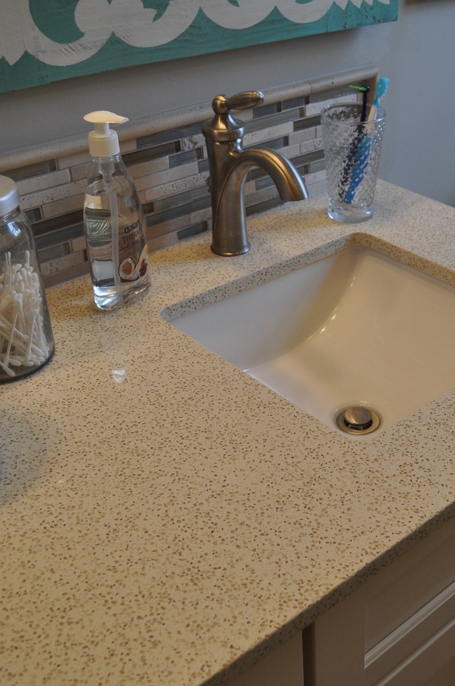 Exemple d'une salle de bain bord de mer avec un lavabo encastré, un plan de toilette en quartz modifié et un carrelage en pâte de verre.
