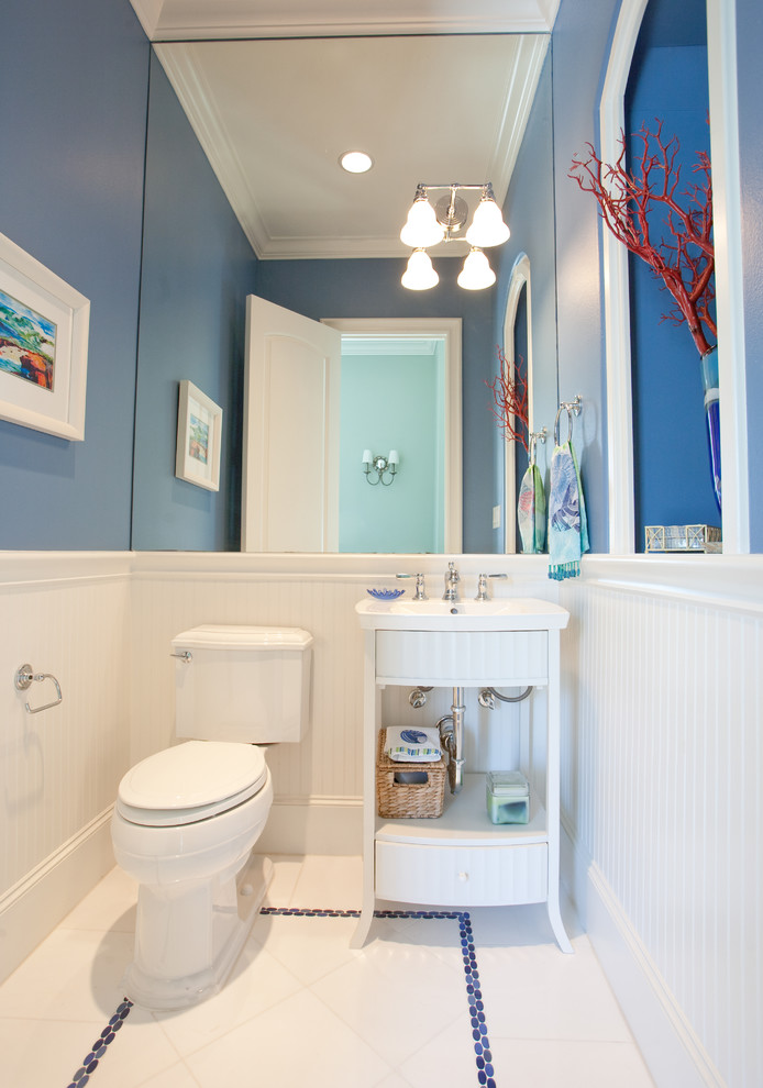 Bild på ett stort maritimt badrum med dusch, med ett integrerad handfat, öppna hyllor, vita skåp, en toalettstol med hel cisternkåpa, vit kakel, porslinskakel, blå väggar och klinkergolv i porslin