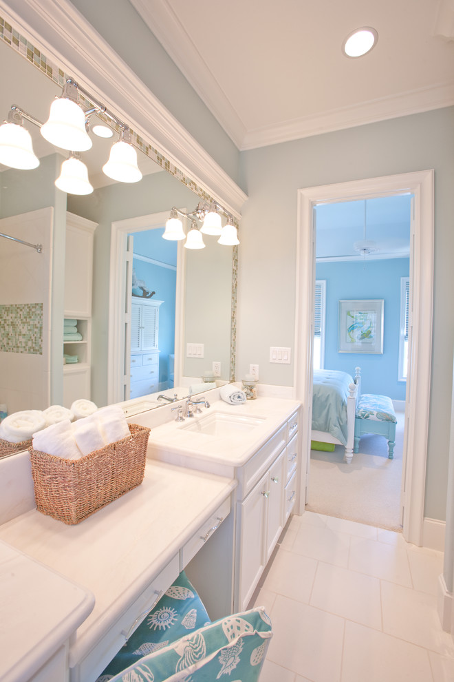 Bild på ett stort vintage en-suite badrum, med ett nedsänkt handfat, luckor med infälld panel, vita skåp, granitbänkskiva, ett platsbyggt badkar, en toalettstol med hel cisternkåpa, vit kakel, porslinskakel, blå väggar och klinkergolv i porslin