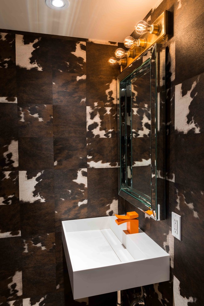 Inredning av ett modernt badrum, med ett väggmonterat handfat och bruna väggar
