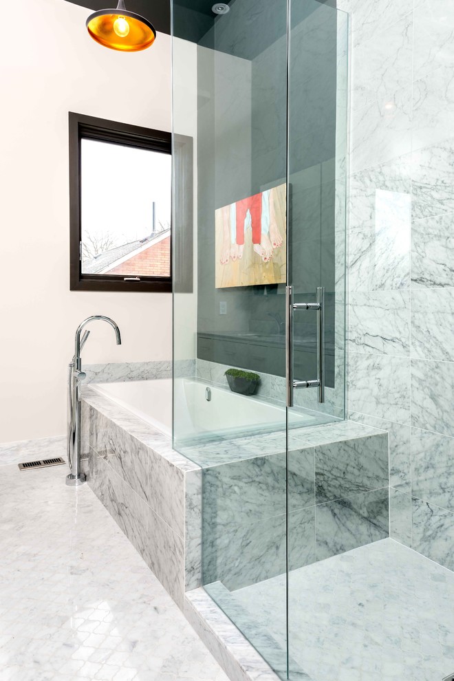 Inredning av ett modernt badrum, med en dusch i en alkov, grå kakel, vita väggar och ett platsbyggt badkar