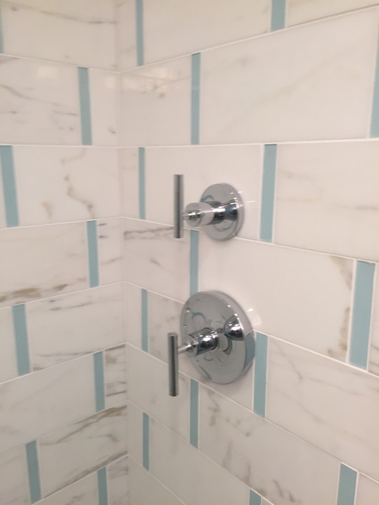Inspiration for a medium sized contemporary shower room bathroom in Jacksonville with a submerged sink, shaker cabinets, white cabinets, marble worktops, a walk-in shower, a two-piece toilet, white tiles, stone tiles, white walls and vinyl flooring.