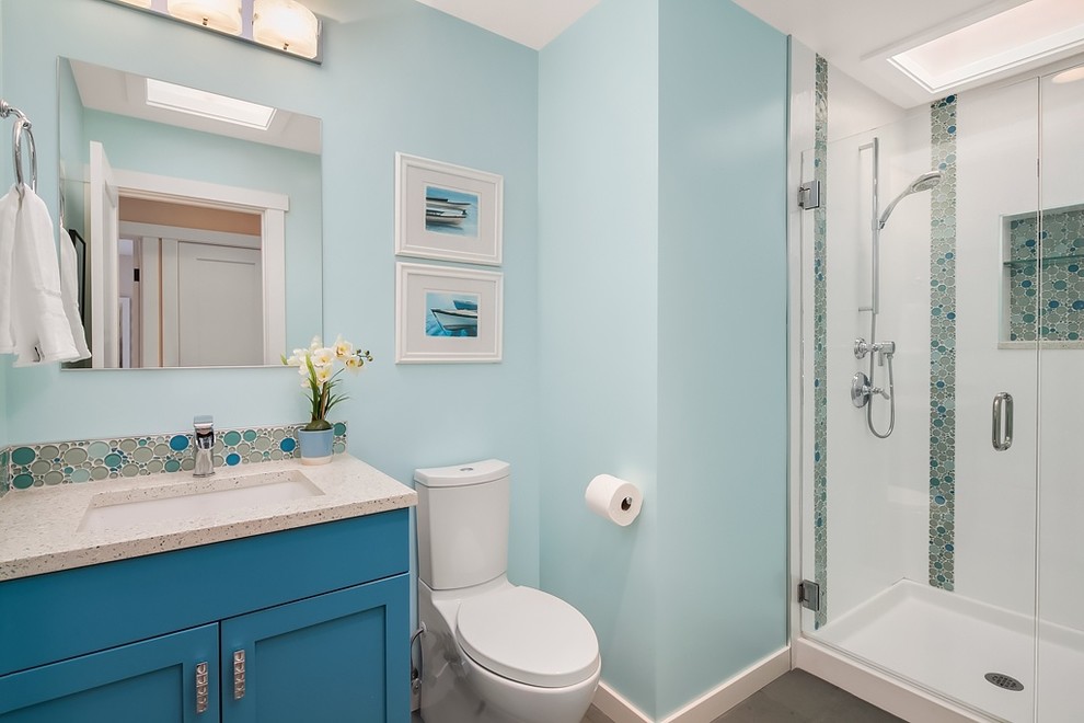 Ispirazione per una stanza da bagno per bambini stile marinaro con ante con bugna sagomata, ante blu, WC a due pezzi, piastrelle blu, piastrelle a mosaico, pareti blu, pavimento in ardesia, lavabo sottopiano e top in vetro riciclato