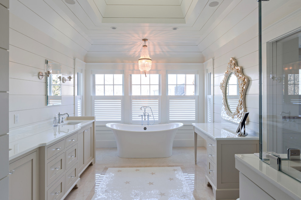Идея дизайна: главная ванная комната в морском стиле с фасадами с утопленной филенкой, бежевыми фасадами, отдельно стоящей ванной, угловым душем, белыми стенами и врезной раковиной