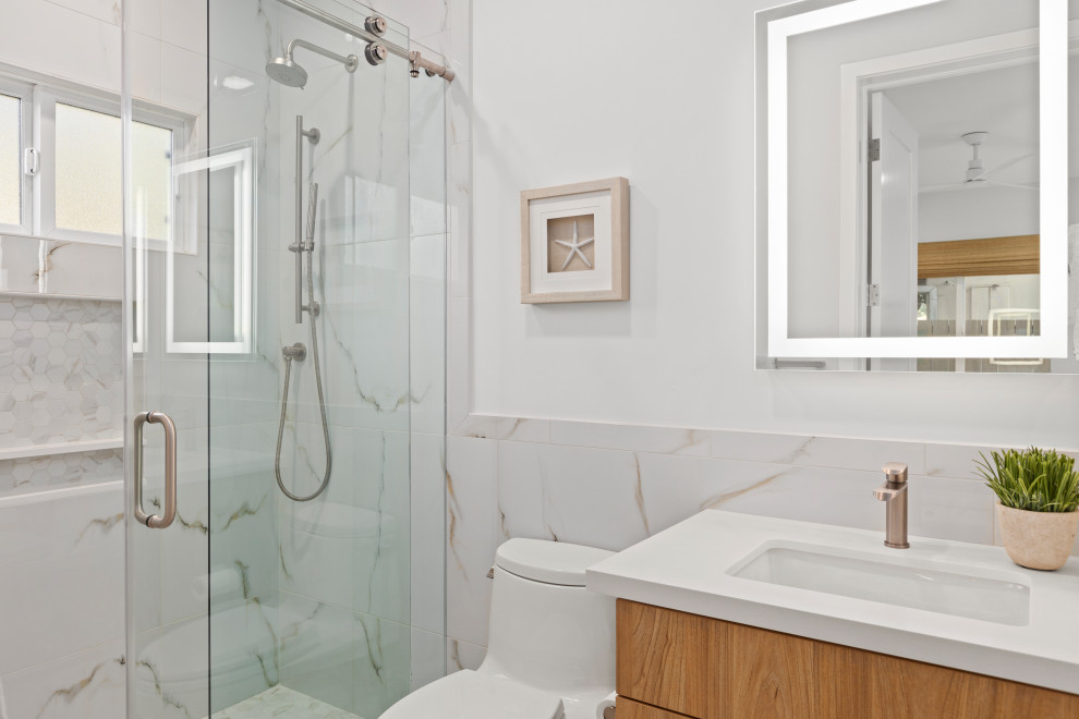 Design ideas for a medium sized bathroom in San Diego with flat-panel cabinets, light wood cabinets, an alcove shower, a one-piece toilet, white tiles, ceramic tiles, grey walls, porcelain flooring, a submerged sink, engineered stone worktops, grey floors, a sliding door and white worktops.