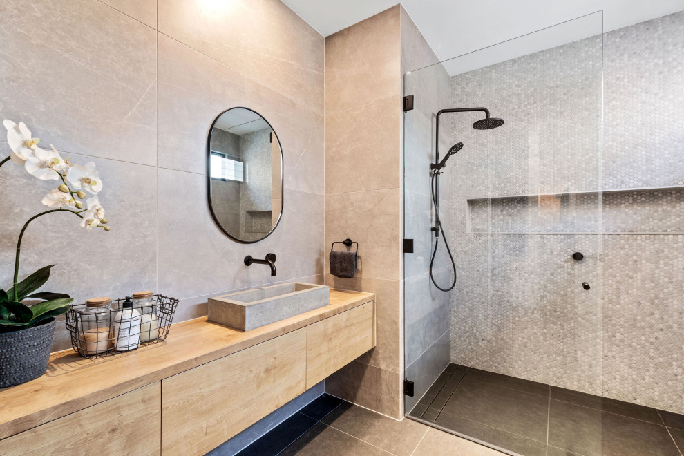 Modernes Badezimmer mit flächenbündigen Schrankfronten, hellen Holzschränken, grauen Fliesen, Mosaikfliesen, Aufsatzwaschbecken, Waschtisch aus Holz, grauem Boden und beiger Waschtischplatte in Sunshine Coast