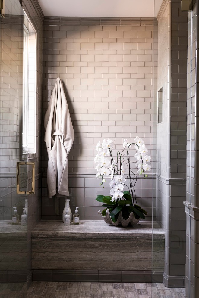 На фото: ванная комната в стиле неоклассика (современная классика) с серой плиткой и душем с распашными дверями с