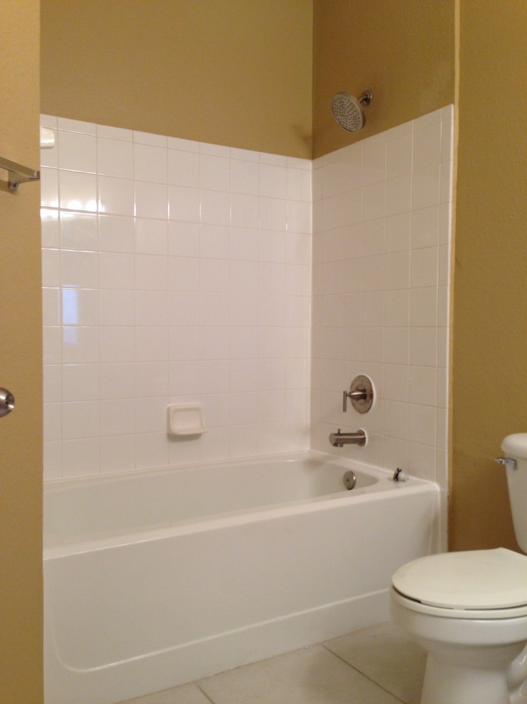 Kleines Klassisches Duschbad mit Einbaubadewanne, Duschbadewanne, Toilette mit Aufsatzspülkasten, weißen Fliesen, Keramikfliesen, gelber Wandfarbe und Keramikboden in Tampa