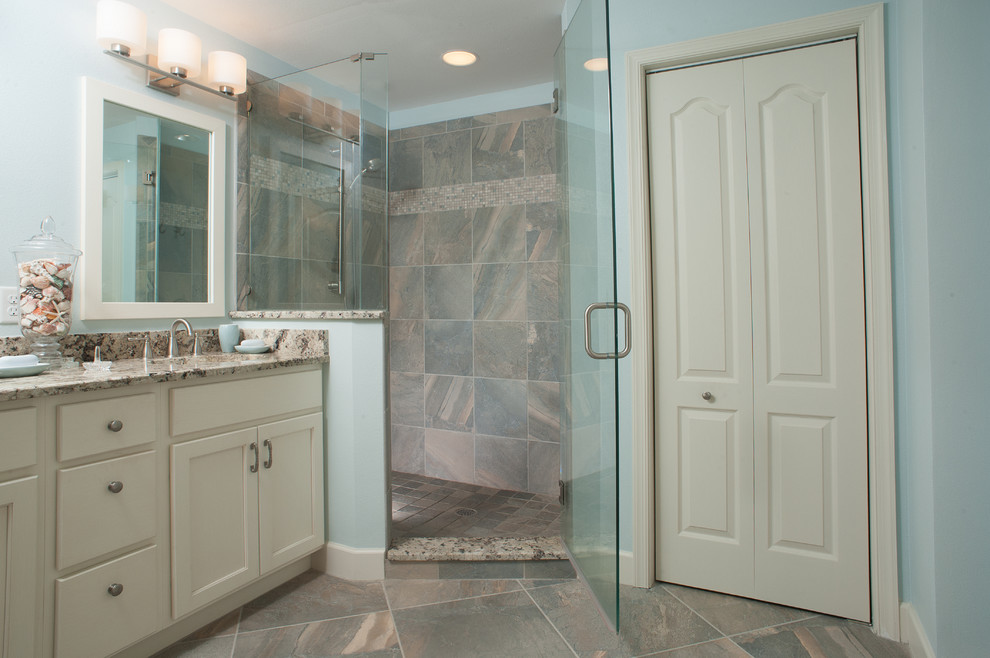 Idéer för att renovera ett mellanstort maritimt en-suite badrum, med ett undermonterad handfat, vita skåp, granitbänkskiva, en hörndusch, grå kakel, porslinskakel, blå väggar, klinkergolv i porslin, luckor med infälld panel, flerfärgat golv och dusch med gångjärnsdörr