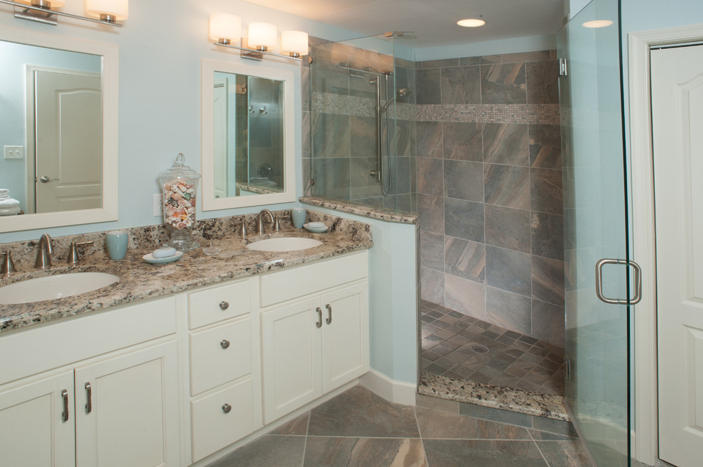 Design ideas for a medium sized beach style ensuite bathroom in Tampa with a submerged sink, white cabinets, granite worktops, a corner shower, grey tiles, porcelain tiles, blue walls, recessed-panel cabinets, slate flooring, multi-coloured floors and a hinged door.