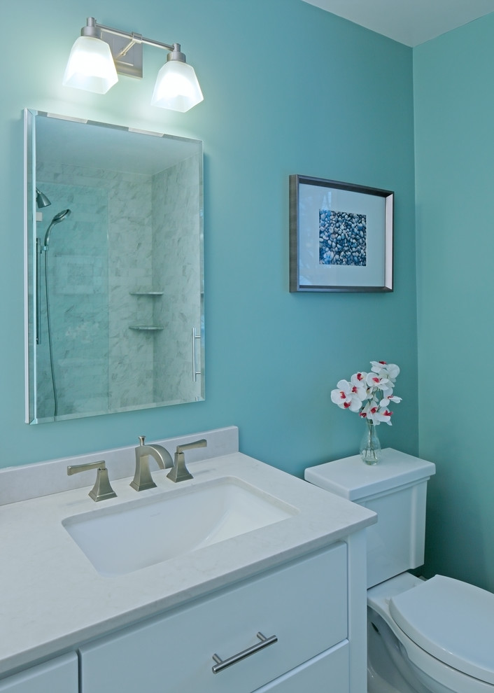 Inspiration for a medium sized traditional ensuite bathroom in New York with a submerged sink, white cabinets, a two-piece toilet, blue walls, flat-panel cabinets, an alcove shower and grey tiles.