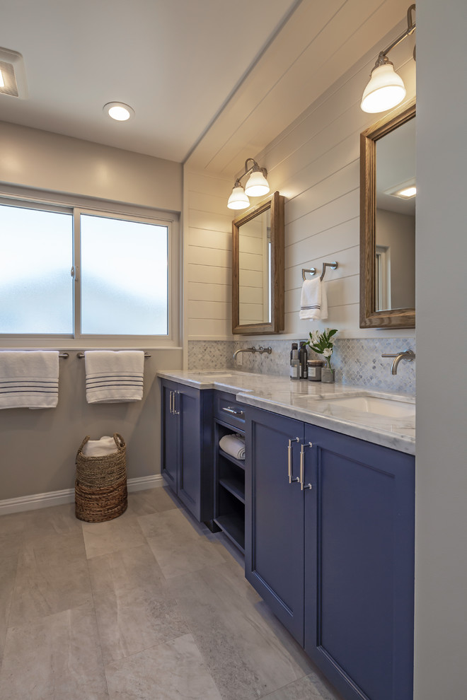 Bathroom - mid-sized transitional kids' gray tile and marble tile vinyl floor and gray floor bathroom idea in San Francisco with shaker cabinets, blue cabinets, an undermount tub, a one-piece toilet, gray walls, an undermount sink, quartz countertops and white countertops