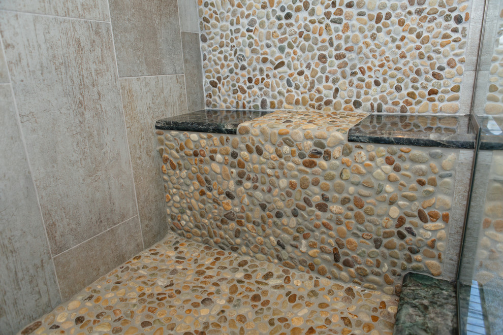 Aménagement d'une douche en alcôve principale bord de mer de taille moyenne avec un carrelage beige, un carrelage de pierre et un sol en galet.