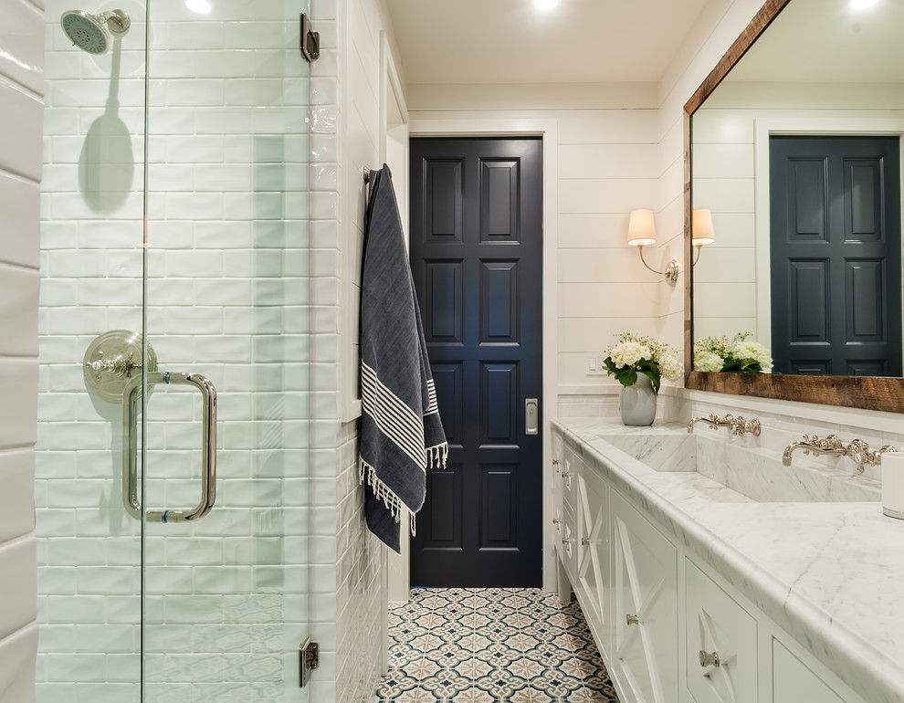 Inspiration for a farmhouse shower room bathroom in San Diego with recessed-panel cabinets, white cabinets, an alcove shower, white tiles, metro tiles, white walls, mosaic tile flooring, a trough sink, marble worktops, multi-coloured floors, a hinged door and grey worktops.