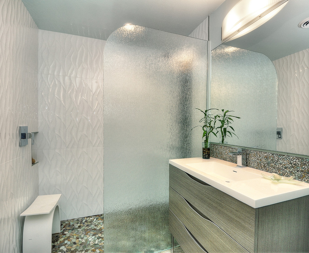 Cette image montre une petite salle de bain principale minimaliste avec un placard à porte plane, des portes de placard grises, une douche à l'italienne, des carreaux de porcelaine, un mur vert, un sol en galet, un plan vasque, un plan de toilette en surface solide, un sol multicolore et aucune cabine.