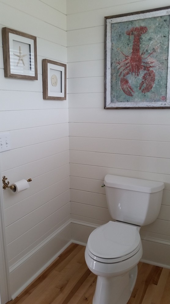 Kleine Maritime Gästetoilette mit Wandtoilette mit Spülkasten, weißer Wandfarbe, hellem Holzboden und Unterbauwaschbecken in Boston