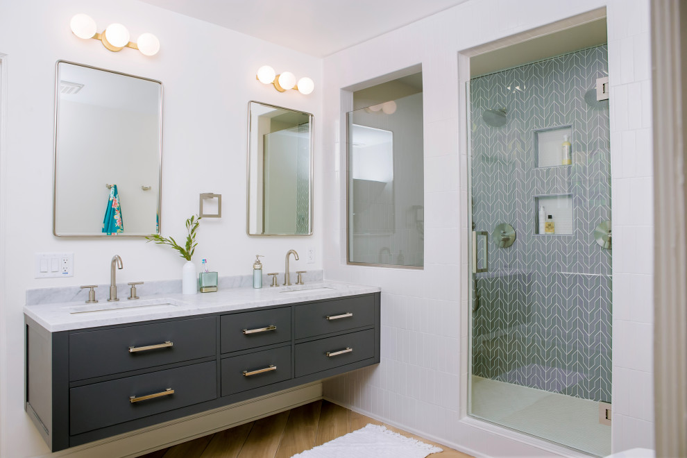 Идея дизайна: ванная комната в стиле неоклассика (современная классика) с плоскими фасадами, серыми фасадами, душем в нише, серой плиткой, белыми стенами, врезной раковиной, коричневым полом, белой столешницей, тумбой под две раковины и подвесной тумбой