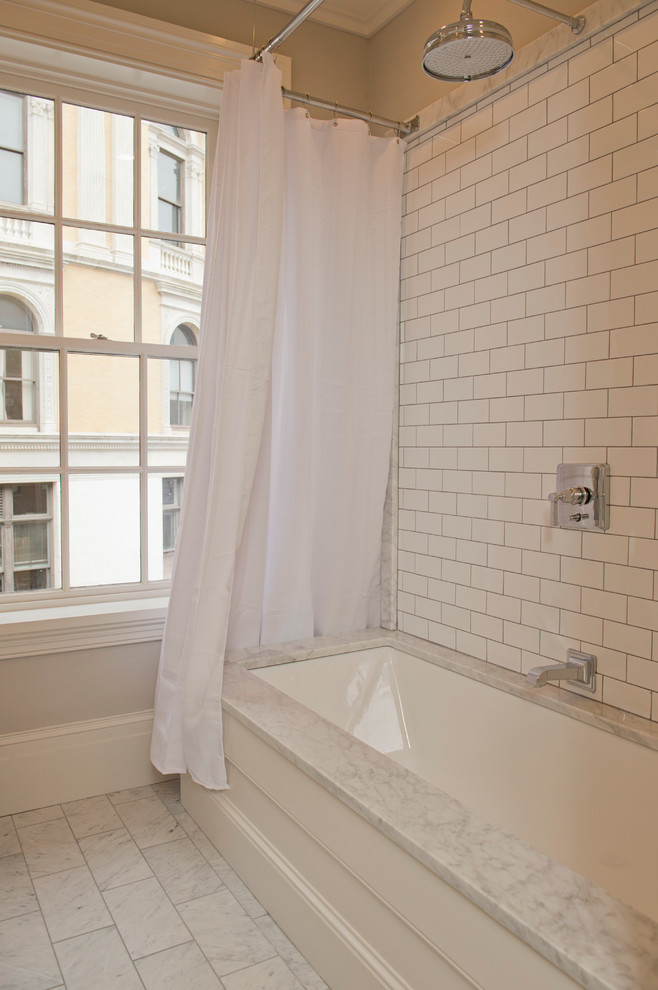 Design ideas for a traditional bathroom in Boston with an alcove bath, a shower/bath combination, white tiles, metro tiles and marble flooring.