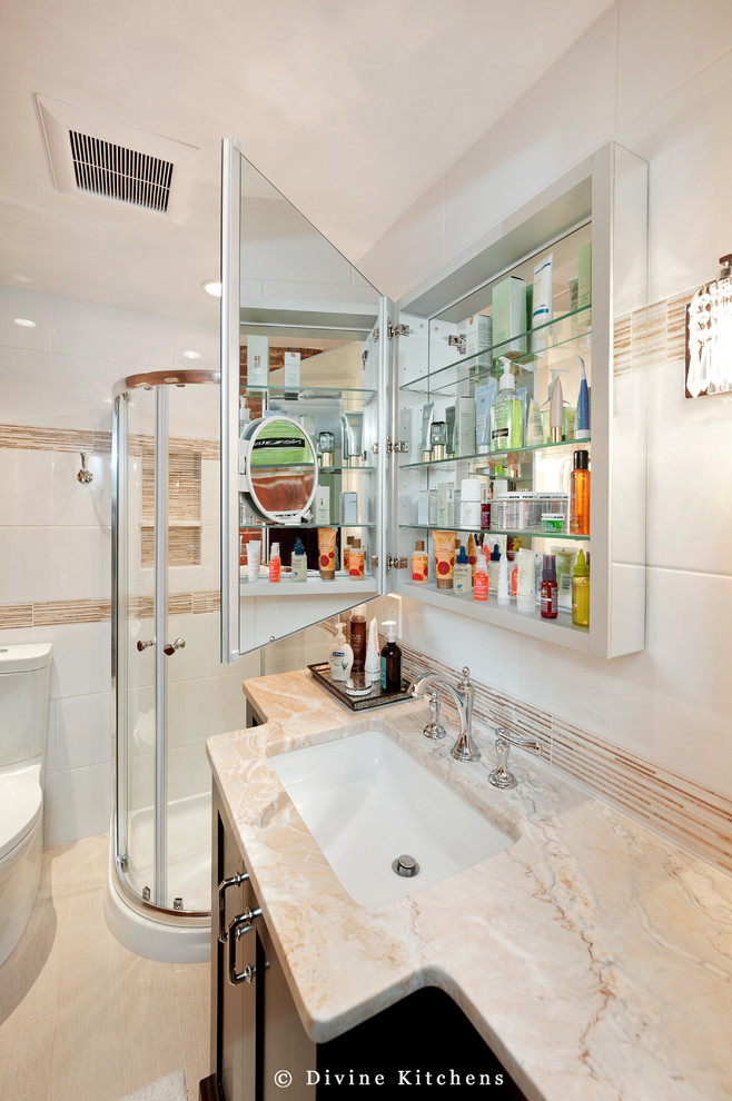 Exemple d'une petite salle de bain principale tendance en bois foncé avec un lavabo encastré, un placard avec porte à panneau surélevé, un plan de toilette en marbre, une douche d'angle, un carrelage beige et un mur blanc.