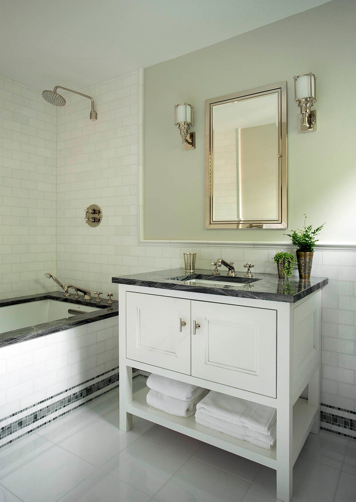 Photo of a traditional bathroom in Boston with recessed-panel cabinets, a submerged bath, beige walls, a submerged sink and grey floors.