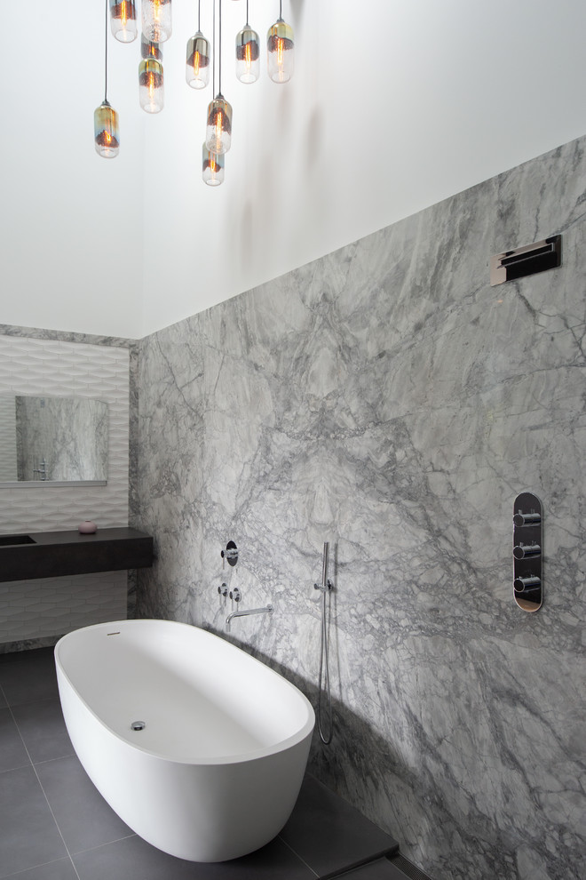 Idéer för ett stort industriellt svart en-suite badrum, med ett fristående badkar, våtrum, grå kakel, marmorkakel, vita väggar, klinkergolv i keramik, ett integrerad handfat, bänkskiva i akrylsten och grått golv