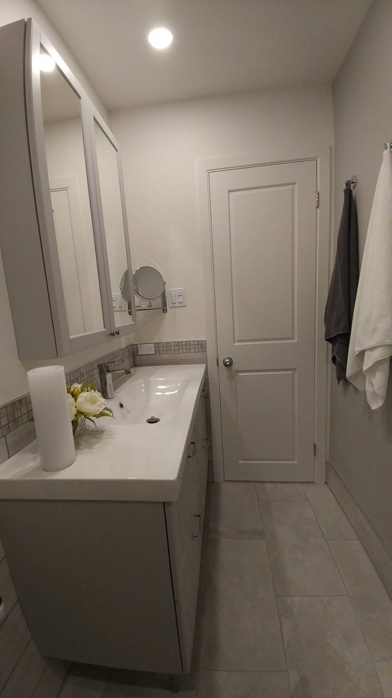 На фото: маленькая главная ванная комната в современном стиле с фасадами в стиле шейкер, серыми фасадами, ванной в нише, душем над ванной, унитазом-моноблоком, серой плиткой, керамической плиткой, белыми стенами, полом из керамической плитки, монолитной раковиной, серым полом, душем с распашными дверями и белой столешницей для на участке и в саду с
