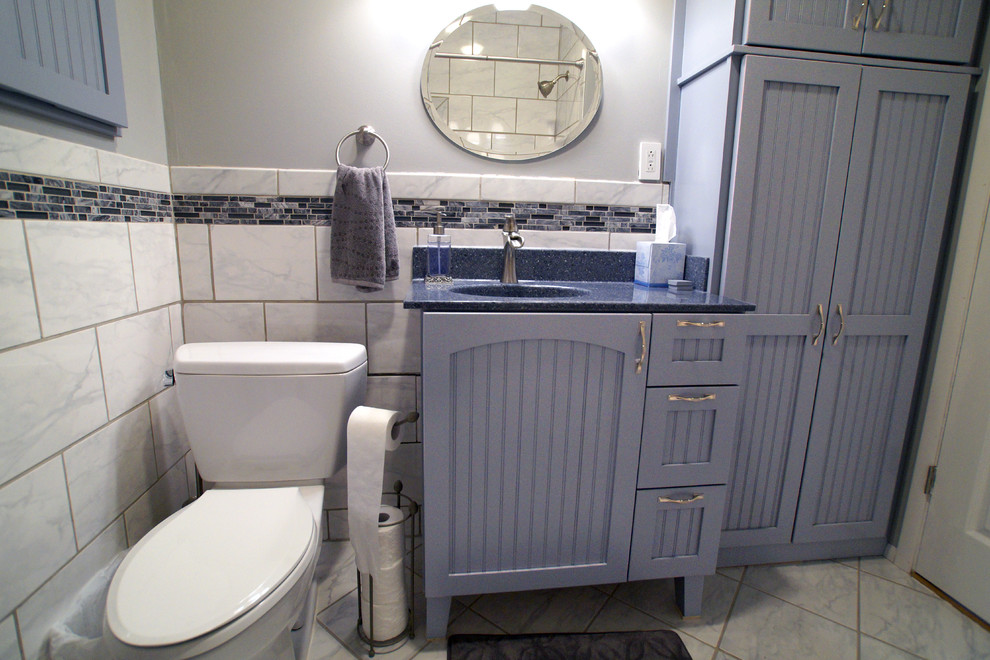 Cette image montre une petite salle de bain rustique avec un lavabo intégré, un placard avec porte à panneau encastré, des portes de placard grises, un plan de toilette en onyx, un carrelage noir et blanc et un sol en carrelage de céramique.