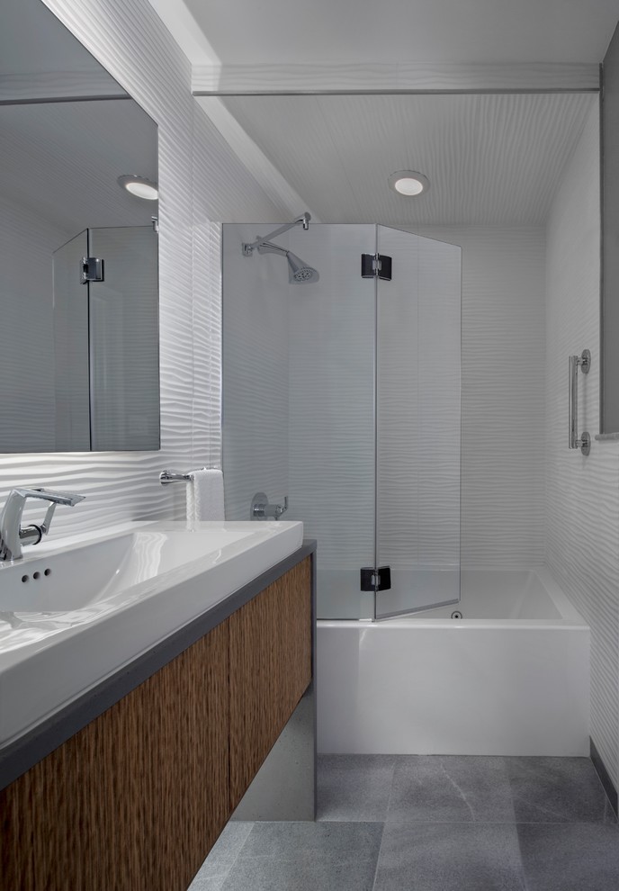 Идея дизайна: маленькая ванная комната в стиле модернизм с плоскими фасадами, коричневыми фасадами, ванной в нише, душем в нише, инсталляцией, белой плиткой, керамической плиткой, белыми стенами, мраморным полом, душевой кабиной, настольной раковиной, столешницей из бетона, серым полом и душем с распашными дверями для на участке и в саду