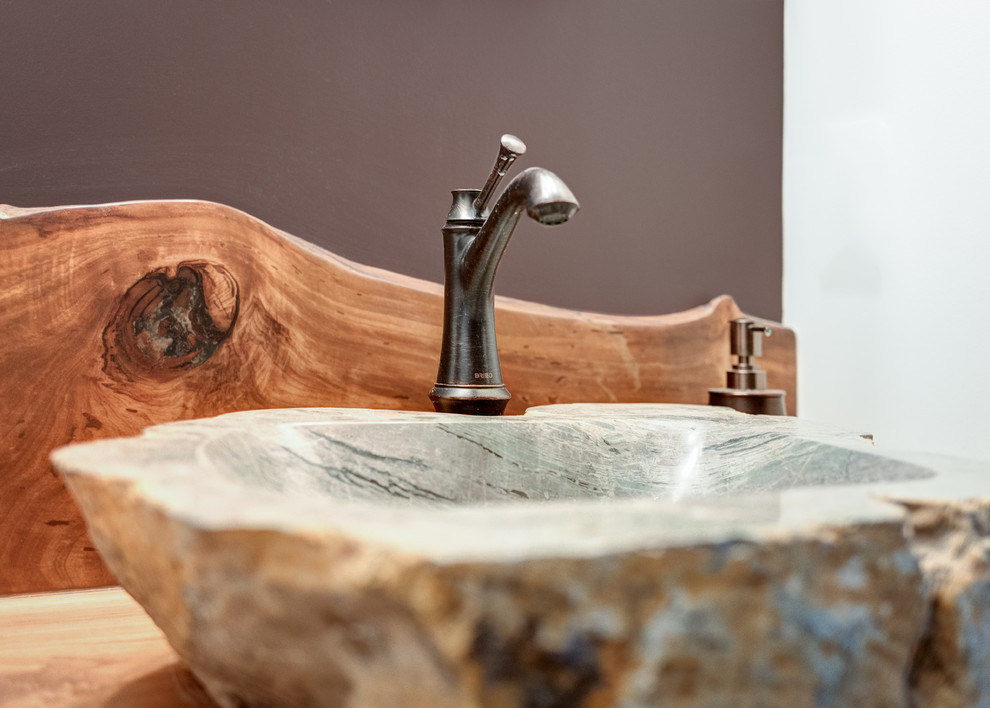 Immagine di una piccola stanza da bagno rustica con pareti marroni, lavabo a bacinella e top in legno