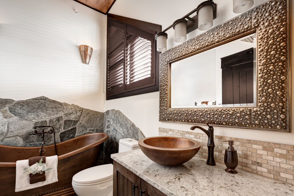 Example of a mountain style gray tile and mosaic tile single-sink and vaulted ceiling freestanding bathtub design in Vancouver with shaker cabinets, dark wood cabinets, white walls, a vessel sink and gray countertops