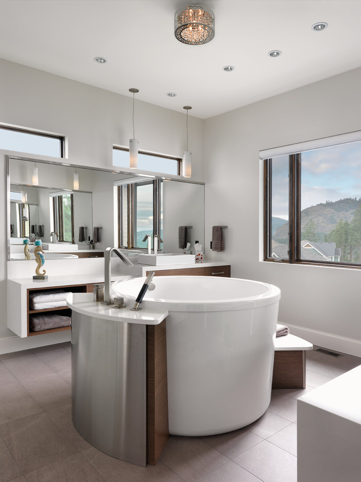 Стильный дизайн: ванная комната в современном стиле с плоскими фасадами, темными деревянными фасадами, отдельно стоящей ванной, белыми стенами и настольной раковиной - последний тренд
