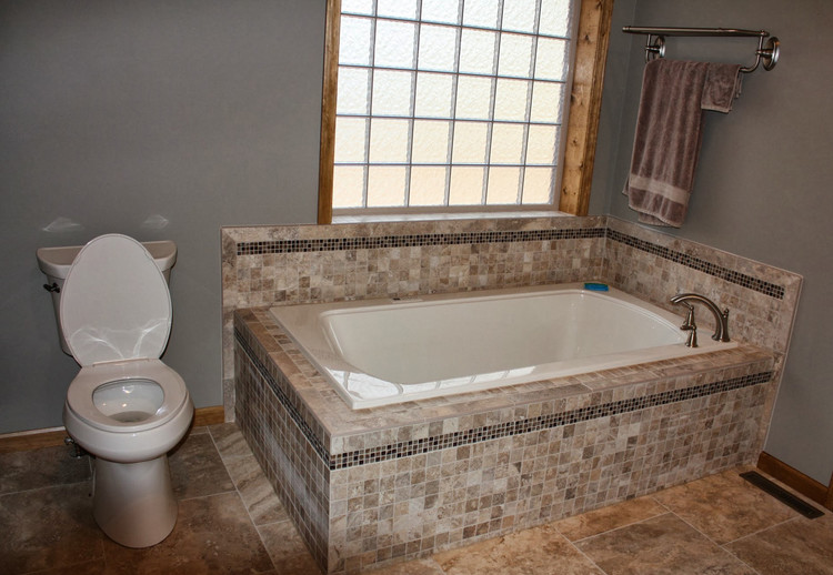 Immagine di una grande stanza da bagno tradizionale con vasca da incasso, WC a due pezzi, piastrelle multicolore, piastrelle a mosaico, pareti grigie e pavimento in gres porcellanato